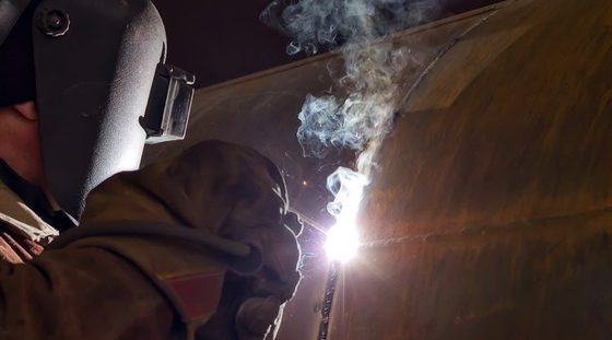 Soudeur au travail sur une virole d'acier