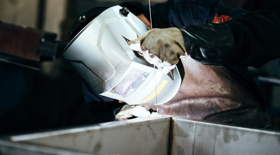 Soudeur tenant sa baguette au-dessus d'une tôle