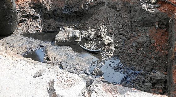 Excavation avec terres polluées et flaque noire