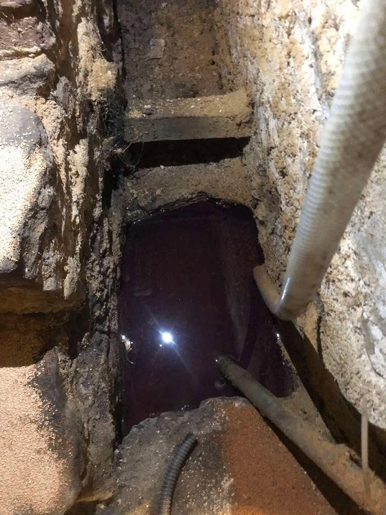 Cuve noire en cave avec un flexible blanc engagé