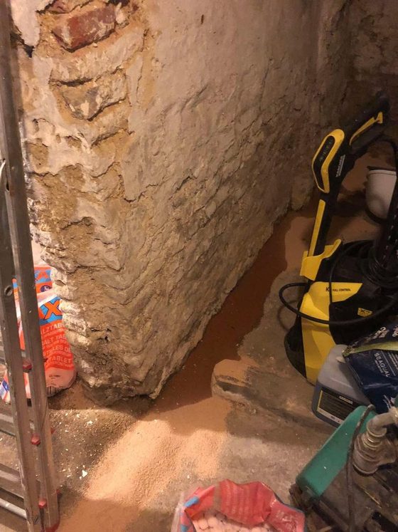 Angle de cave avec sol sablé et outils posés