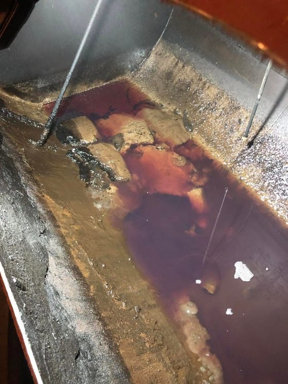 Fond d'une cuve avec dépôts et eau rouillée