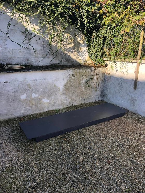 Socle rectangulaire posé au sol dans une cour