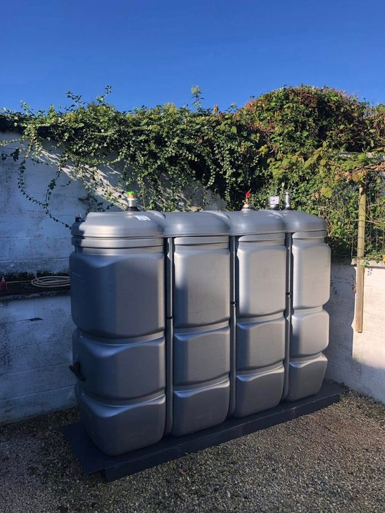 Cuves en polyéthylène sur socle, mur blanc derrière