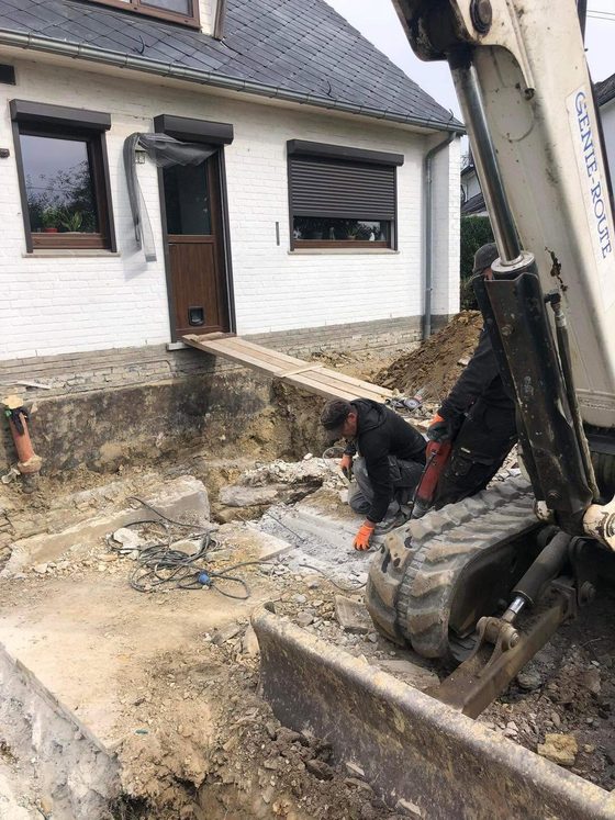 Minipelle travaillant devant une maison, terre ouverte