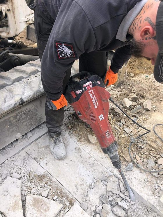 Ouvrier au marteau-piqueur sur une dalle béton
