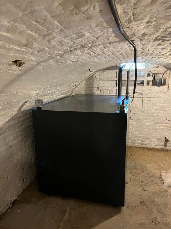 Citerne noire dans une cave voûtée blanchie
