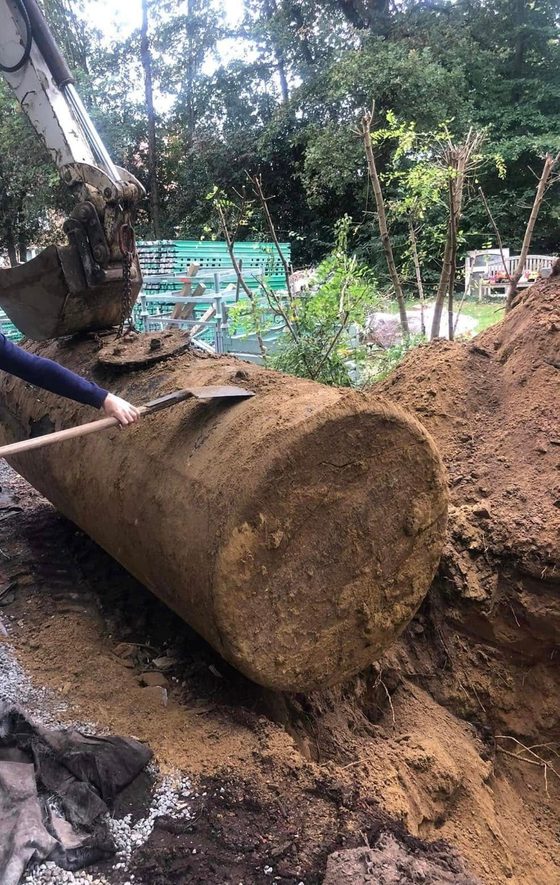 Citerne terreuse posée au sol près d'une pelle