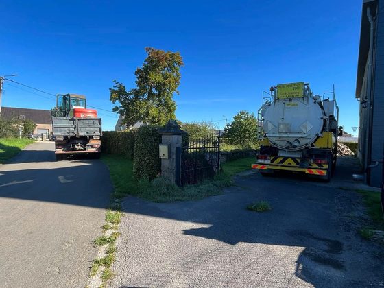 Deux camions stationnés devant un portail