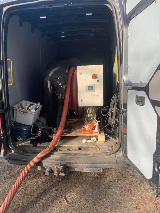 Arrière d'une camionnette avec flexible rouge et coffret