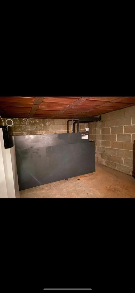 Citerne noire alignée le long d'un mur de cave