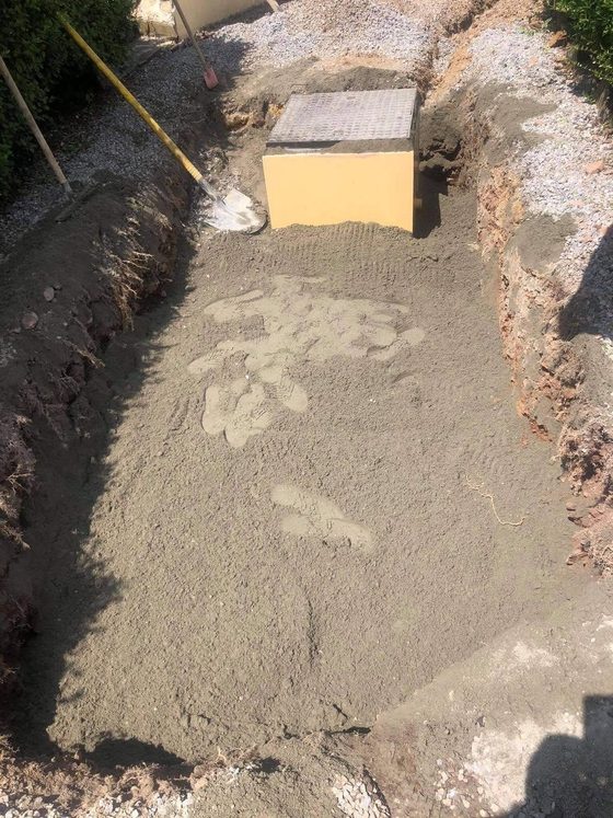 Fouille avec lit de sable nivelé et bloc de béton