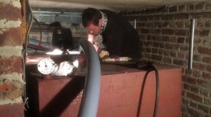 Opérateur et ses manomètres dans une cave en brique