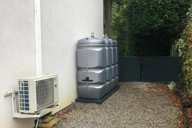 Citerne en polyéthylène de petite capacité installée sur gravier, le long d’une allée